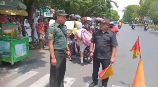 Babinsa Tembok Dukuh Bantu Siswa Sekolah Menyeberang Jalan