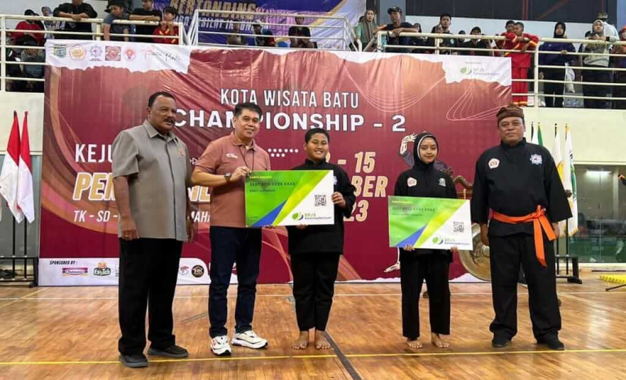 Imron Fatoni, Kepala BPJamsostek Surabaya Darmo menyerahkan simbolis kepesertaan kepada atlet pencak silat yang berlaga pada Kota Wisata Batu Championship 2.