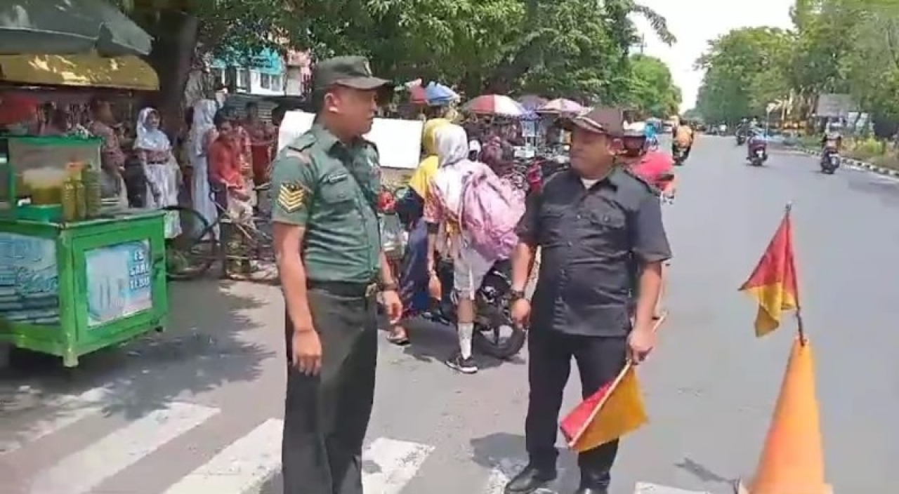 Babinsa Tembok Dukuh Bantu Siswa Sekolah Menyeberang Jalan